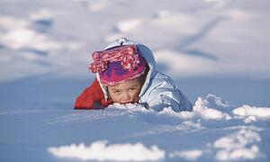 Young girl playing in the snow on a winter afternoon