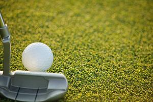 Closeup of putter and ball