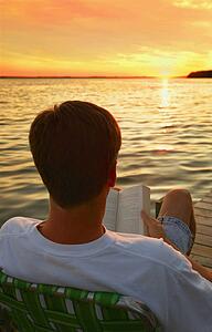 Man reading a book at the lake