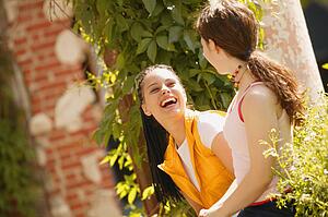 Two girls share a joke