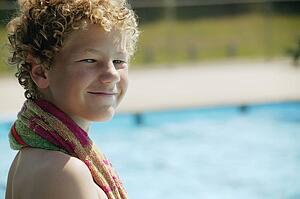 Boy sits beside the pool