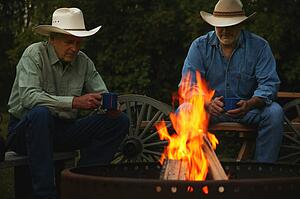 Two men sitting by a fire
