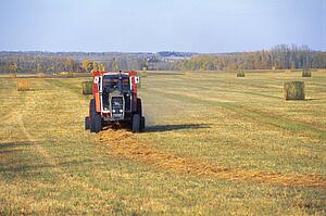 Heavy machinery makes bales of hay