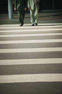 Businessmen walk across street