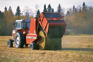 Tractor making bales