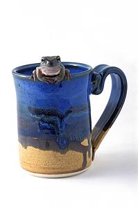 Frog drinks cup of coffee
