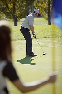 Woman holds flag on putting green