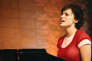 Woman plays the piano and sings