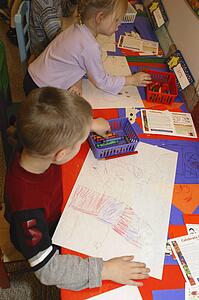Preschool age children drawing Halloween pictures in class