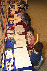 Preschool age children drawing pictures in their kindergarten class