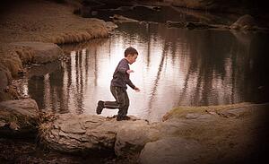 Child plays by water