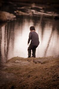 Child plays by water