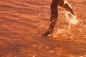 Child Running through water on beach 