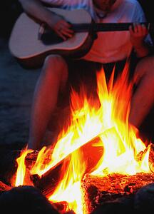 Playing guitar by a bonfire