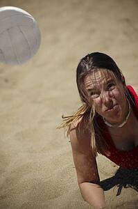 A woman plays beach volleyball
