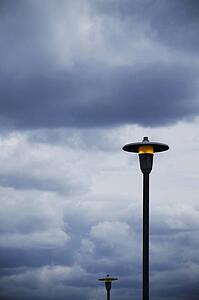 Lamp posts and cloudy sky