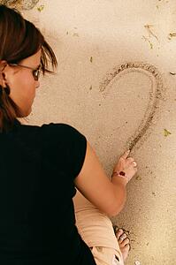 Woman draws in the sand