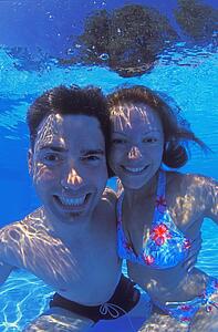 Portrait of happy couple underwater in swimming pool
