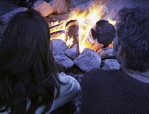 Couple sit by the fire