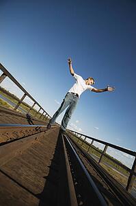 Teen walks on train tracks