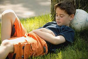 Child sleeps on soccer ball