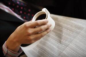Reading the newspaper and drinking coffee