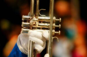 A gloved hand holds a trumpet