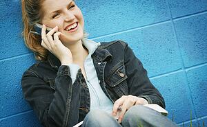 Student with textbook and cell phone