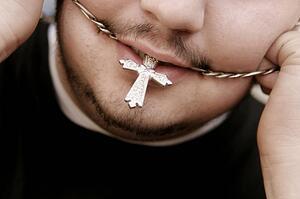A man with necklace in his mouth