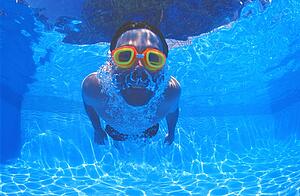 Boy with goggles in swimming pool