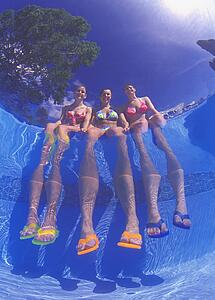 Girls dangling feet in pool