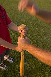 Male and boy's arms with baseball bat