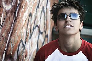 A teen by a wall of graffiti