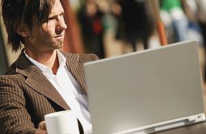 Businessman sitting at computer with coffee