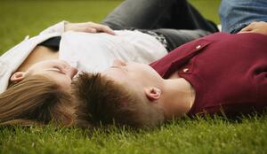 Couple lying face up on grass