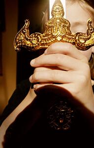 Hands clasping ornamental sword