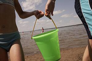 Two children carrying bucket
