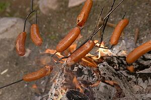 Cooking sausages over charcoal