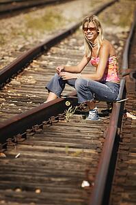 Woman sitting on train tracks