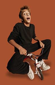 Teenage boy on tiny bicycle
