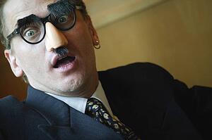 Businessman looking surprised wearing Groucho Marx disguise