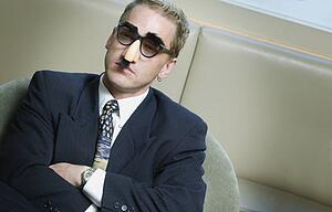 Serious businessman wearing Groucho Marx mask disguise
