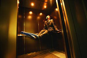 Businessman with flippers & goggles on in elevator