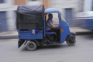 ma driving a three-wheeled van