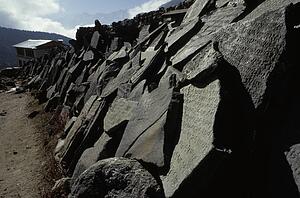 Broken carved stones alongside path