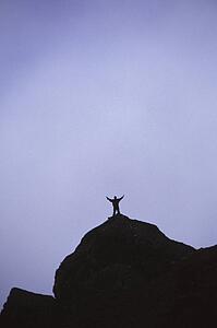 Lone hiker on top of mountain peak