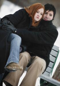 Couple sitting on bench in winter