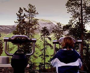 Tourist using scope to see the mountain