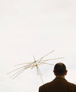 Man holding useless umbrella