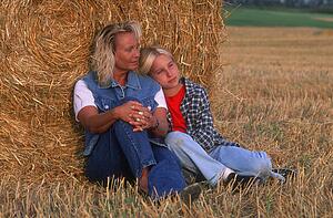 Mom and daughter relaxing in the hayfield
